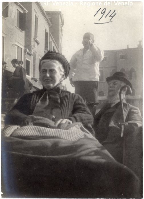 Ritratto della Principessa Borghese - Ritratto: all'esterno, mezza figura, in semi profilo - Donna: anziana, sorridente, seduta in gondola - Vestiario: cappello con nastro - Fondale: Uomo con barba, cappello, bastone, gondoliere, palazzi, persone  di Filippi, Tomaso (primo quarto XX)