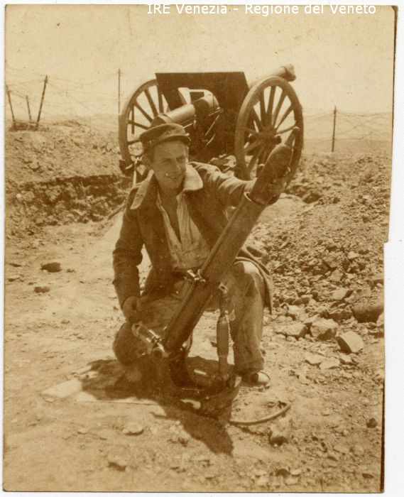 Rudolf Schulze in Marocco - Ritratto: all'esterno, figura intera, in semi profilo - Uomo: in ginocchio - Vestiario: giacca, camicia, berretto - Armi: cannone, mortaio - Pietre - Macerie - Filo spinato  di Anonimo (secondo quarto XX)