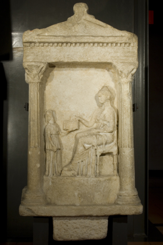 figura femminile seduta rivolta verso sinistra e (a sinistra) un'ancella che regge un cofanetto (rilievo, stele a frontone con rilievo funerario e iscrizione, a Philoumene) - Ambito culturale greco (sec. II a.C. (?))