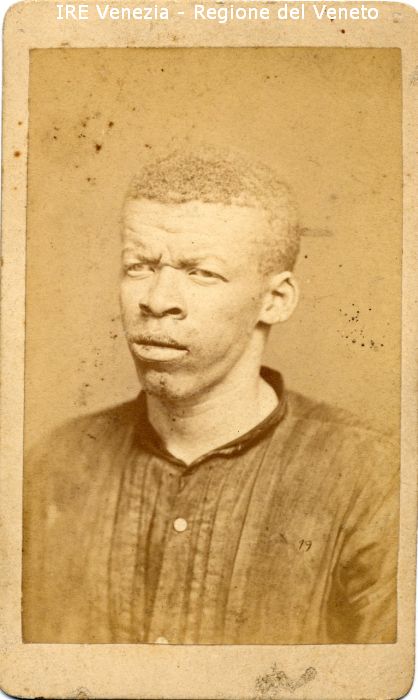 Ritratti: in studio; mezzo busto; in semi profilo - Uomo: di razza africana; albino - Vestiario: camicia - Sfondo  di Naya, Carlo (seconda metà XIX)